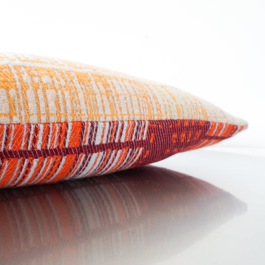 Detail of jacquard-woven pillow by Emma Terweduwe in peach and orange tones