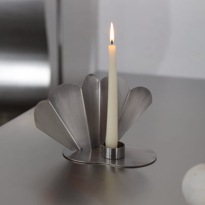 PAONNE candleholder in brushed stainless steel with fan-shaped petal base and lit taper candle, by The Good Living & Co.