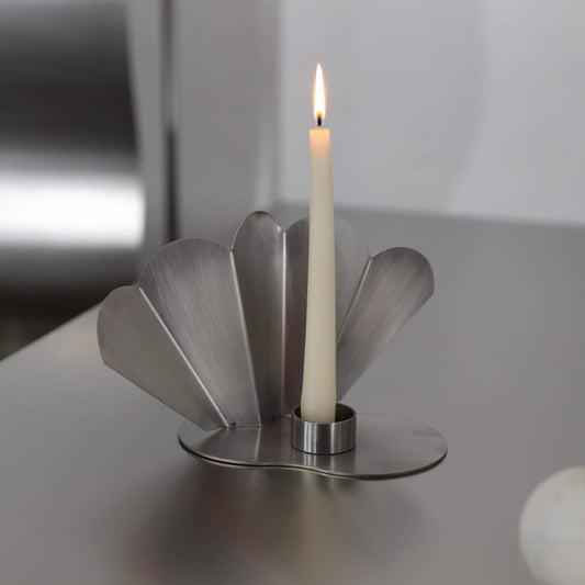 PAONNE candleholder in brushed stainless steel with fan-shaped petal base and lit taper candle, by The Good Living & Co.