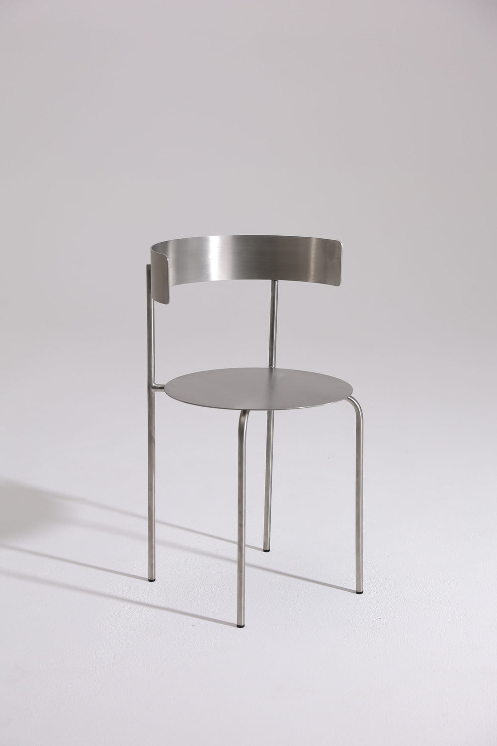 MEADOW chair in brushed stainless steel with curved backrest, minimalist design by The Good Living & Co.