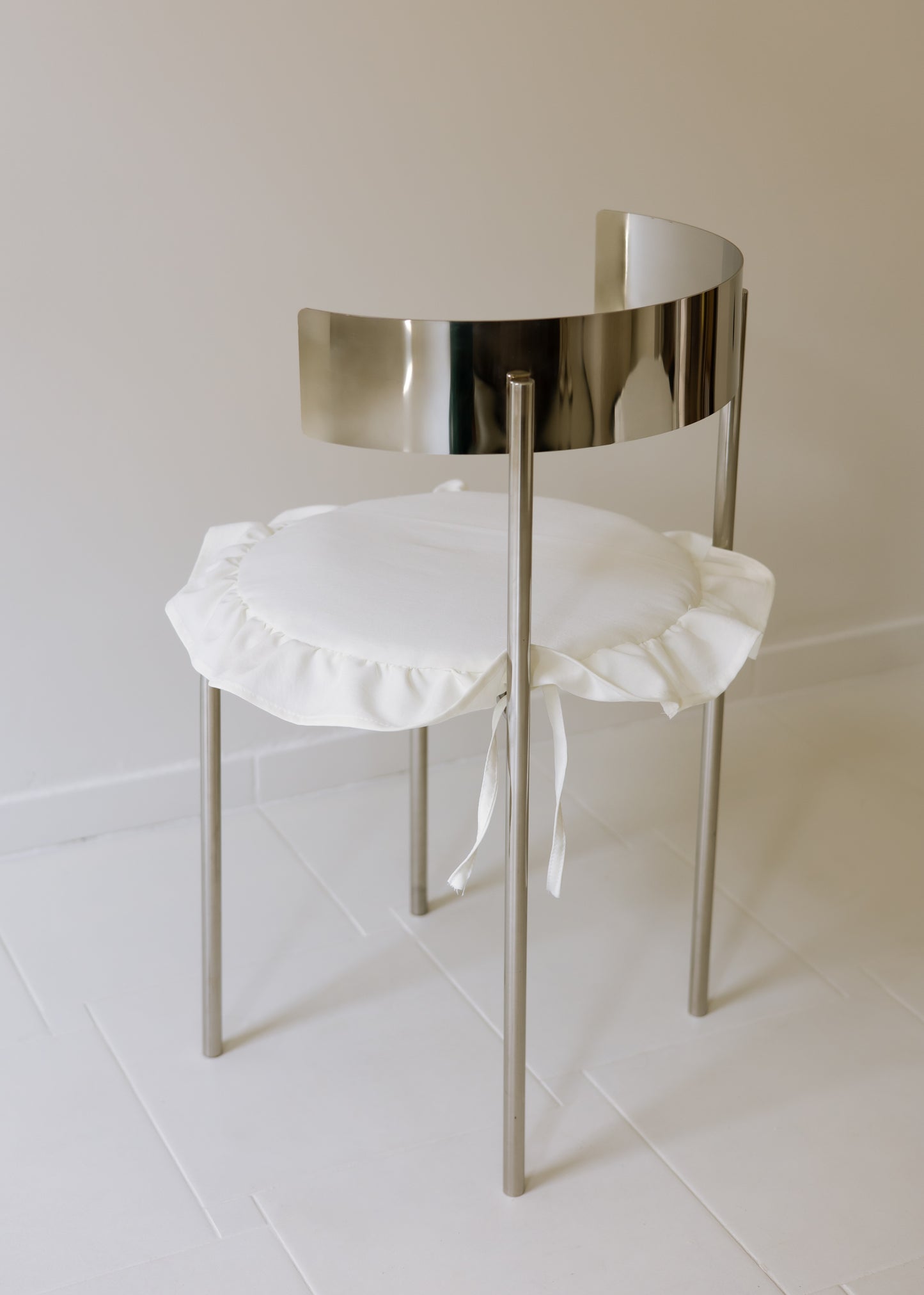 MEADOW chair with white ruffled cushion and reflective steel frame, made to order by The Good Living & Co.