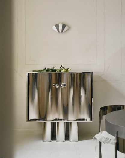 MOTION polished stainless steel commode with sculptural wave-front doors, side angle view, by The Good Living & Co.