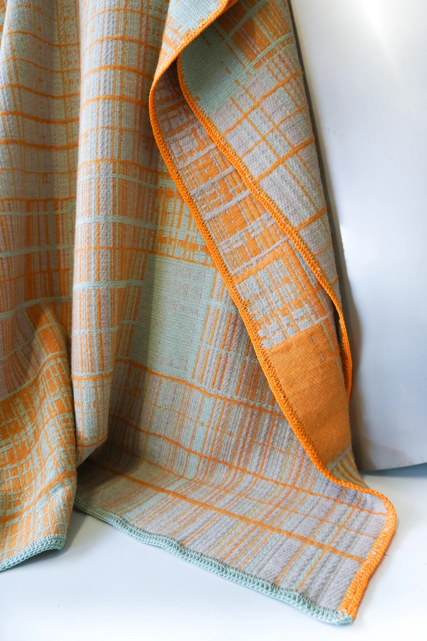 Detail of jacquard-woven plaid blanket by Emma Terweduwe in peach and yellow tones