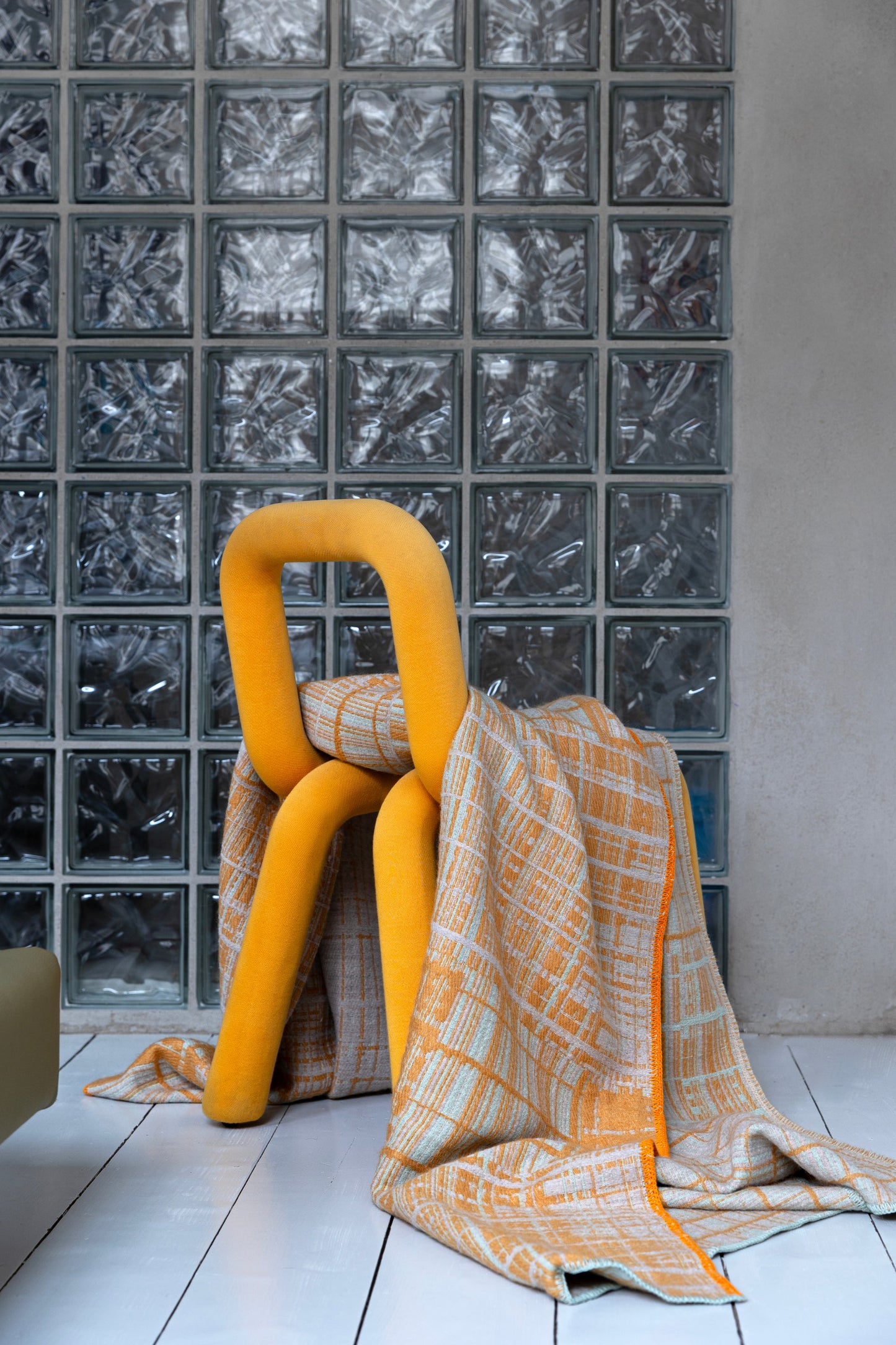 Jacquard-woven plaid blanket by Emma Terweduwe styled with yellow sculptural chair