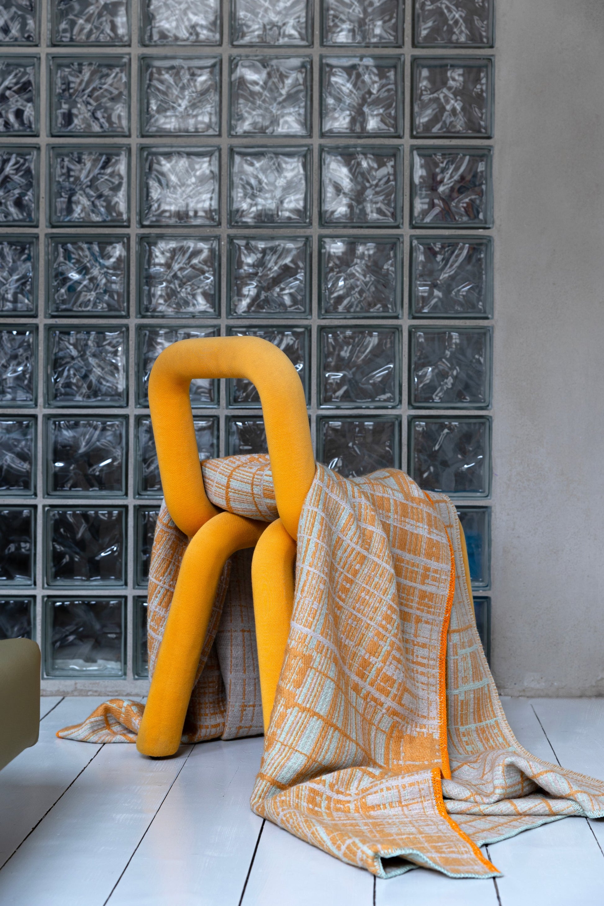 Jacquard-woven plaid blanket by Emma Terweduwe styled with yellow sculptural chair
