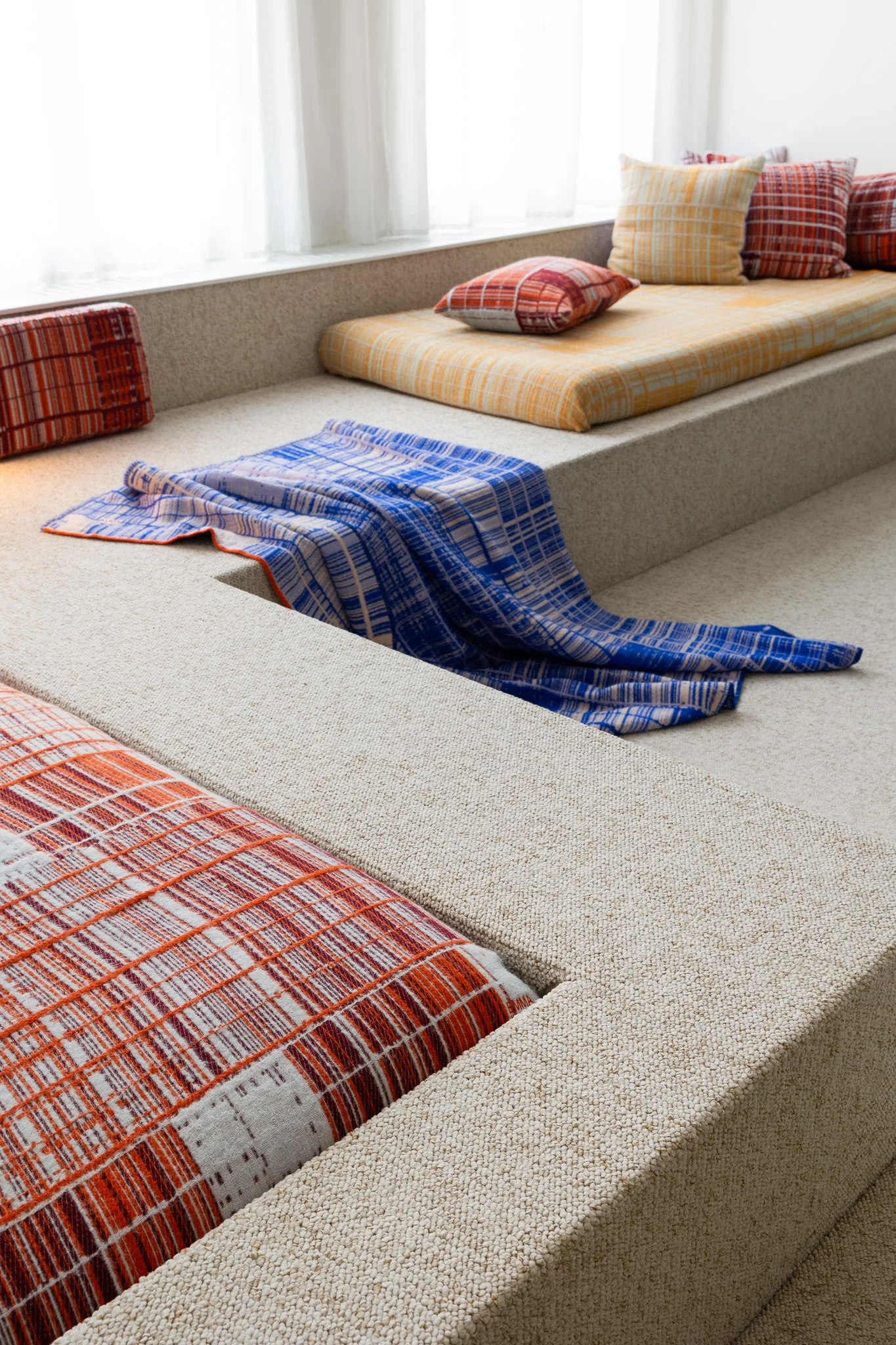 Emma Terweduwe woven blanket and cushions styled on a built-in sofa in a contemporary interior