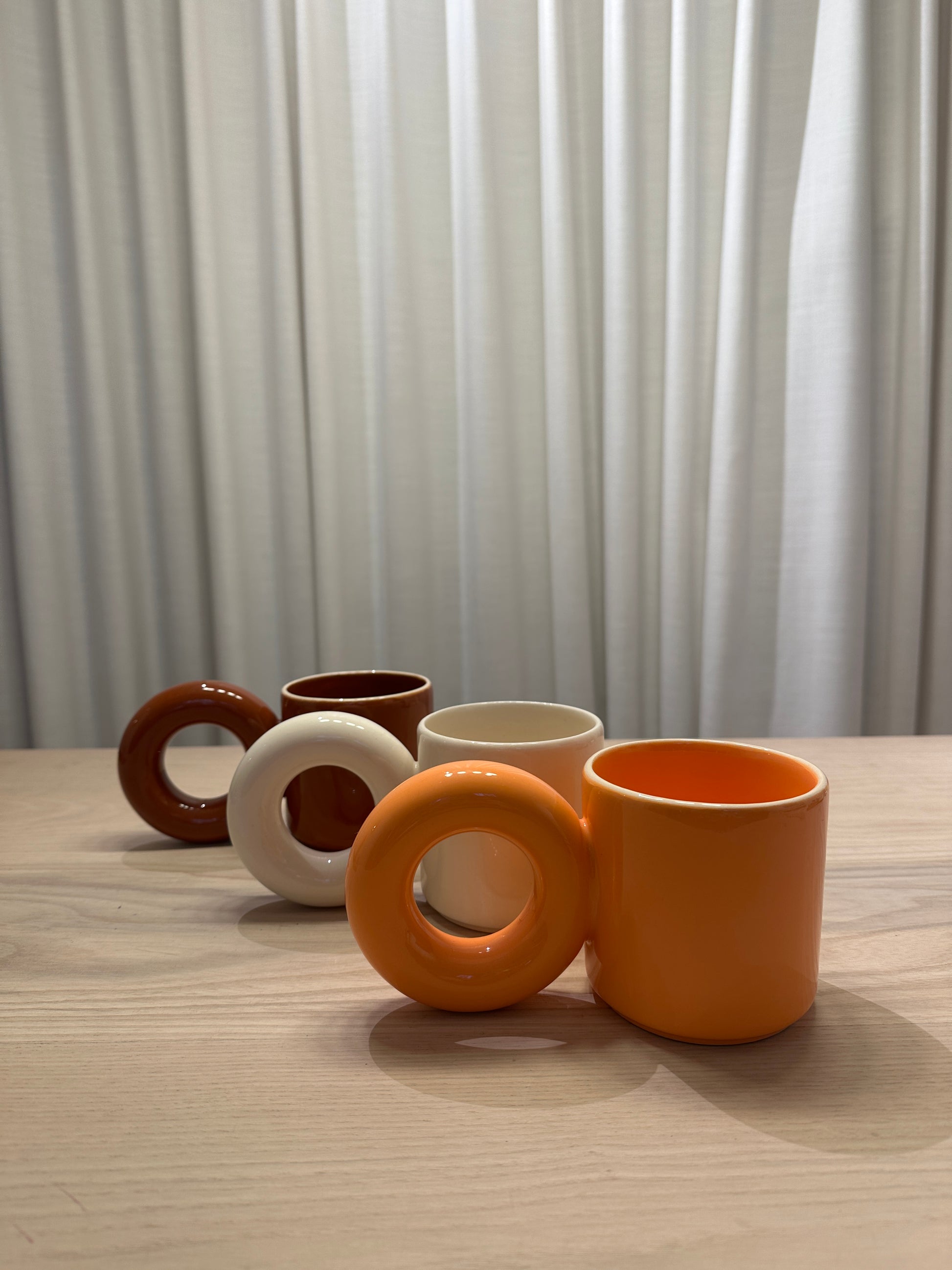 Designer mokken van Malwina Konopacka in verschillende kleuren, met de sculpturale ronde oor-greep en handgemaakte keramische afwerking uit de gecureerde RUIMTE collectie.