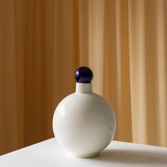 Contemporary ceramic ecru vase by Malwina Konpacka with a playful cobalt ball on top making the vase a stand alone object without flowers, collection avaiable in Ruimte. 