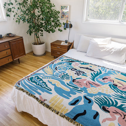 Kimbie woven throw blanket by Maitaimai styled on a bed as a functional art textile