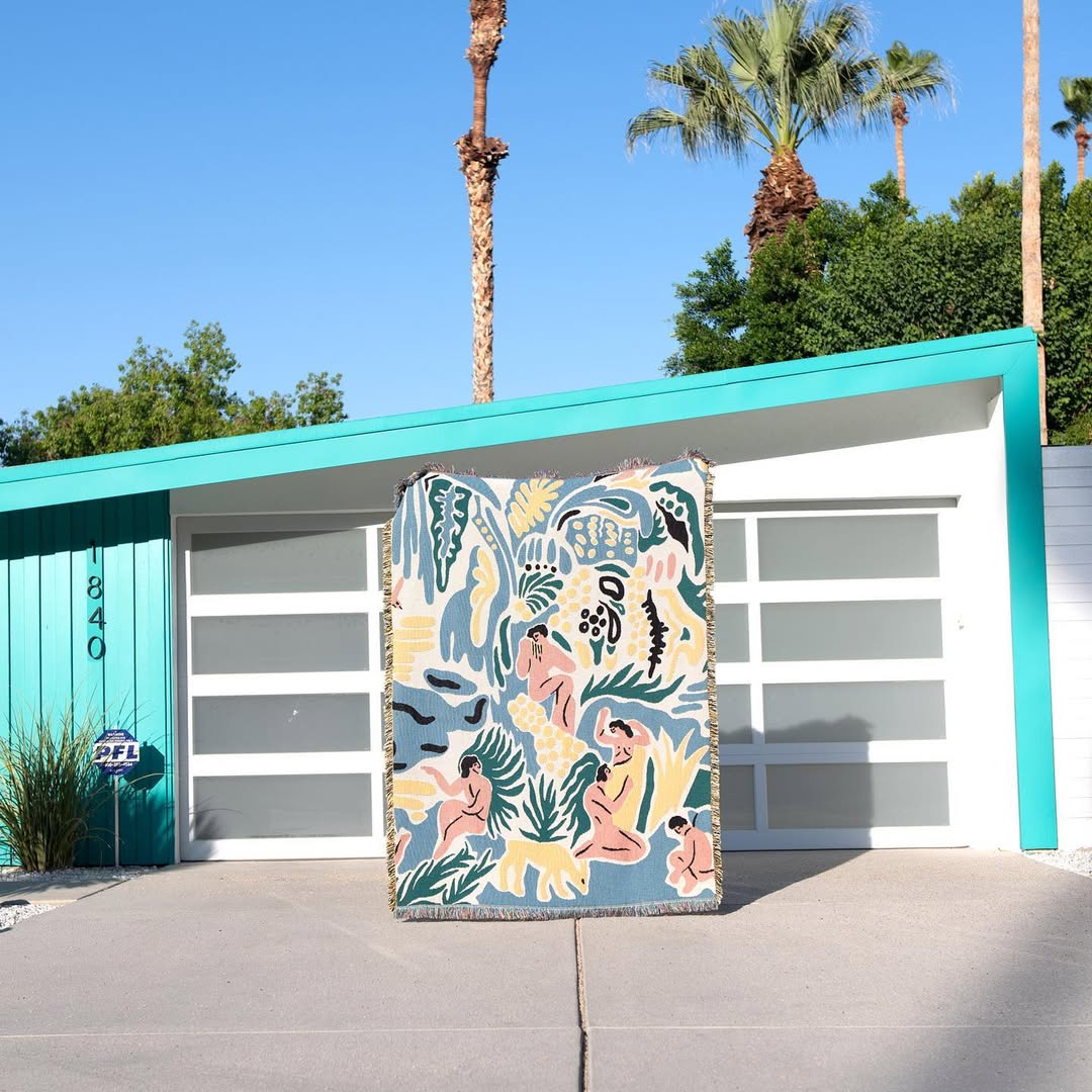 Kimbie woven throw blanket by Maitaimai hanging as textile wall art in an outdoor setting