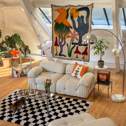 Dumont woven throw blanket by Roisin O’Donnell displayed on the wall as textile art in a living room interior