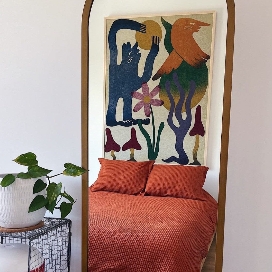 Dumont woven throw blanket by Roisin O’Donnell styled as textile wall art behind a bed
