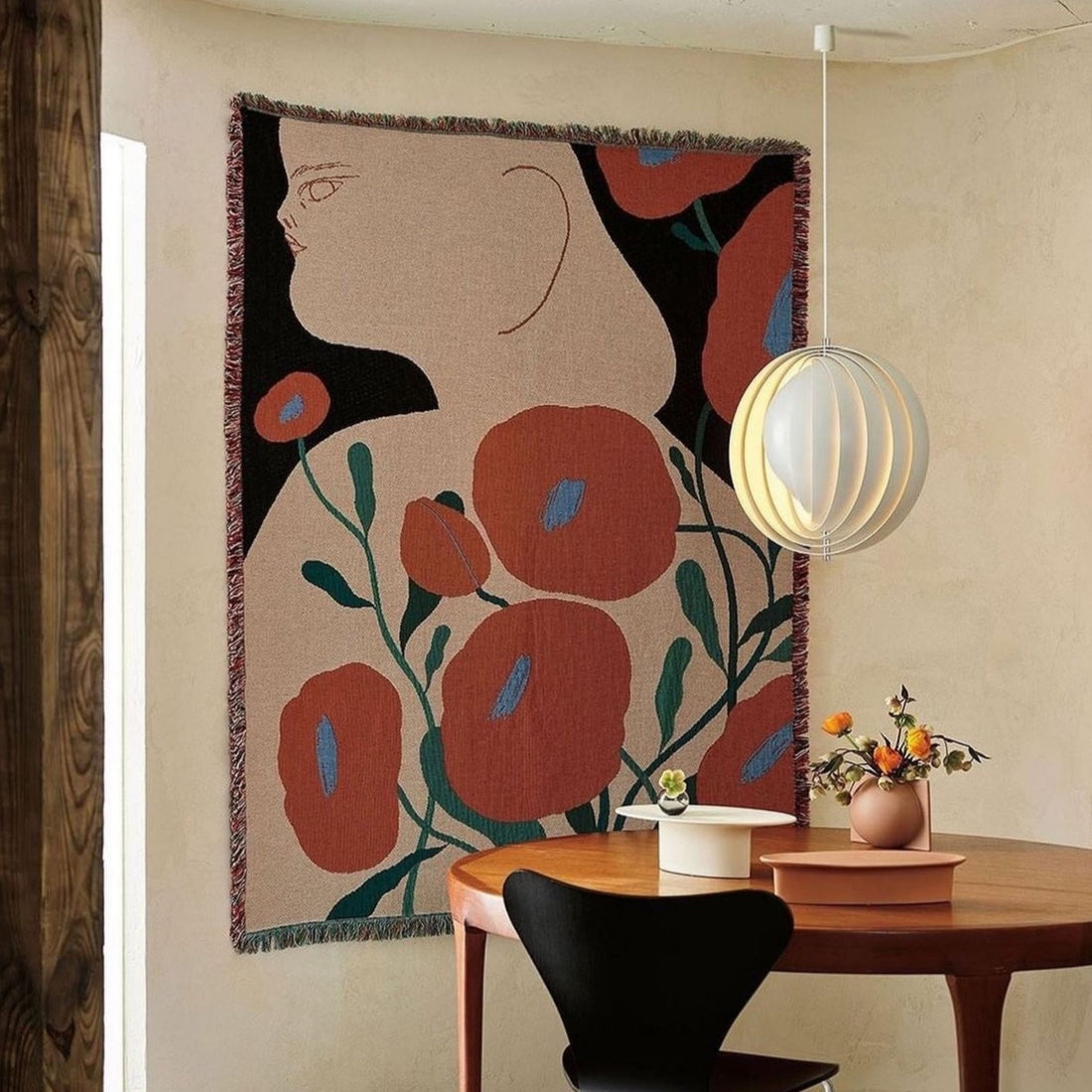 Melba woven throw blanket by Suvi Suitiala displayed on the wall as textile art in a modern interior