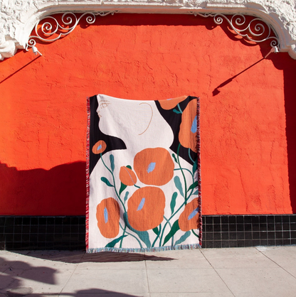 Melba woven throw blanket by Suvi Suitiala hanging as textile wall art in an outdoor setting